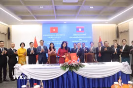 Bộ trưởng Bộ Văn hóa, thể thao và du lịch Việt Nam Lâm Thị Phương Thanh và Bộ trưởng Bộ Văn hóa và thể thao Lào Suonsavan Vinhaket trao đổi văn kiện hợp tác. (Ảnh: Xuân Tú/TTXVN)