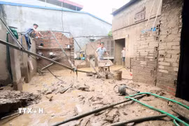 Nhân dân xã Chiềng Sơ (tỉnh Sơn La) san gạt bùn. (Ảnh: Quang Quyết/TTXVN)