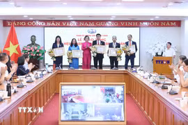 Đồng chí Vũ Việt Trang, Ủy viên Ban Thường vụ Đảng ủy các cơ quan Đảng Trung ương, Bí thư Đảng ủy, Tổng Giám đốc Thông tấn xã Việt Nam, Phó Trưởng ban Tuyên giáo Trung ương trao Huy hiệu cho các đồng chí 40 năm; 35 năm và 30 năm tuổi Đảng. (Ảnh: An Đăng/TTXVN)