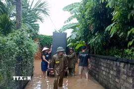 Lực lượng chức năng ở Bắc Ninh hỗ trợ người dân di chuyển tài sản đến nơi an toàn. (Ảnh: Đồng Thúy/TTXVN)
