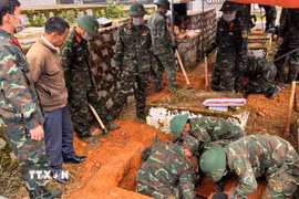 Các chiến sỹ đang tổ chức khai quật hài cốt liệt sỹ để đưa về Nghĩa trang Liệt sỹ Đà Lạt. (Ảnh TTXVN phát)