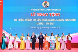 Phó Thủ tướng Thường trực Chính phủ Nguyễn Hòa Bình, Chủ tịch Tổng Liên đoàn Lao động Việt Nam Nguyễn Đình Khang trao tặng biểu trưng và chứng nhận Giải thưởng “Nữ đoàn viên công đoàn năng động, sáng tạo, trách nhiệm” cho 10 cá nhân. (Ảnh: Minh Đức/TTXVN)