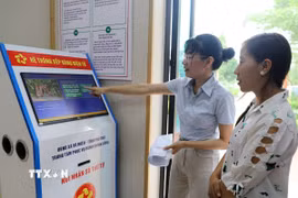 Người dân xã Võ Miếu (Phú Thọ) lấy số tự động, giúp giảm thiểu thời gian chờ đợi và bảo đảm tính công bằng, trật tự khi làm thủ tục. (Ảnh: Tạ Toàn/TTXVN)