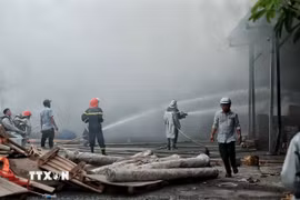 Sau hơn nửa tiếng, lực lượng Cảnh sát Phòng cháy chữa cháy và Cứu nạn cứu hộ với đầy đủ trang thiết bị đã khống chế được đám cháy. (Ảnh: Phạm Tuấn Anh/TTXVN)