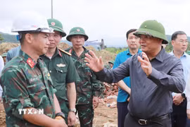 Bí thư Tỉnh ủy Lai Châu, Lê Minh Ngân động viên lực lượng Quân đội đang thi công xây dựng nhà cho các hộ dân vùng lũ tại bản Sân Bay, xã Mường Than. (Ảnh: Quý Trung/TTXVN)