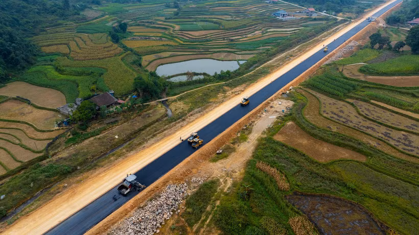 Nhà thầu thi công thảm nhựa nền đường một dự án đường bộ cao tốc. (Ảnh: PV/Vietnam+)