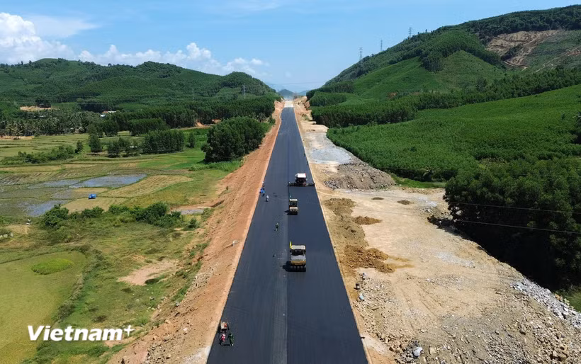 Nhà thầu thi công thảm bêtông nhựa nền đường một tuyến cao tốc. (Ảnh: Khánh Hùng/Vietnam+)