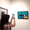 Họa sỹ không hướng tới việc tái hiện con mèo theo lối tả thực, mà anh vẽ mèo với sự giản lược về hình thể, đường nét được biến đổi; dáng mèo trở thành hình khối, đường cong, nhịp điệu và tương quan trên mặt tranh. (Ảnh: Minh Thu/Vietnam+)