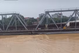 Đoàn tàu chở hàng nặng 300 tấn được bố trí án ngữ trên cầu đường sắt sông Thương để đối phó nước lũ trước nguy cơ cuốn trôi cầu. (Ảnh: PV/Vietnam+)
