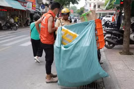 Một tài xế chạy ứng dụng gọi xe giao hàng bị lực lượng cảnh sát giao thông xử lý vi phạm che biển số. (Ảnh: PV/Vietnam+)