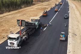 Nhà thầu thi công thảm nhựa nền đường một Dự án đường bộ cao tốc. (Ảnh: Việt Hùng/Vietnam+)