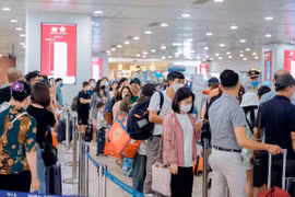 Hành khách làm thủ tục trước khi lên máy bay. (Ảnh: PV/Vietnam+)