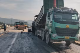 Nhà thầu thi công thảm nhựa nền đường một dự án đường bộ. (Ảnh: Việt Hùng/Vietnam+)