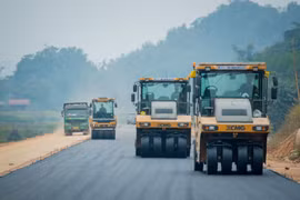 Nhà thầu thi công thảm nhựa nền đường một dự án đường bộ cao tốc. (Ảnh: PV/Vietnam+)