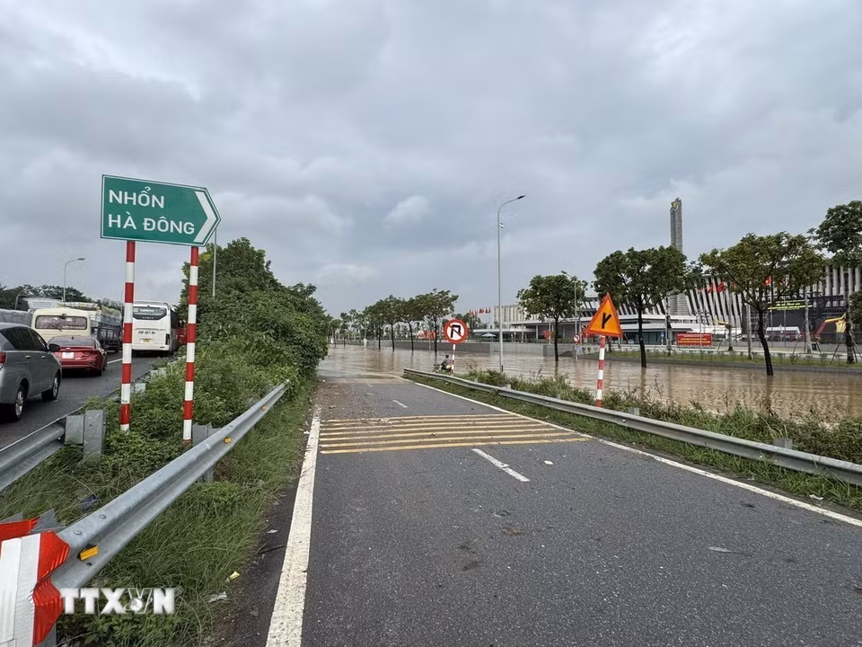 Nước ngập đường gom khiến các phương tiện tràn lên đường cao tốc. (Ảnh: Quốc Lũy/TTXVN)