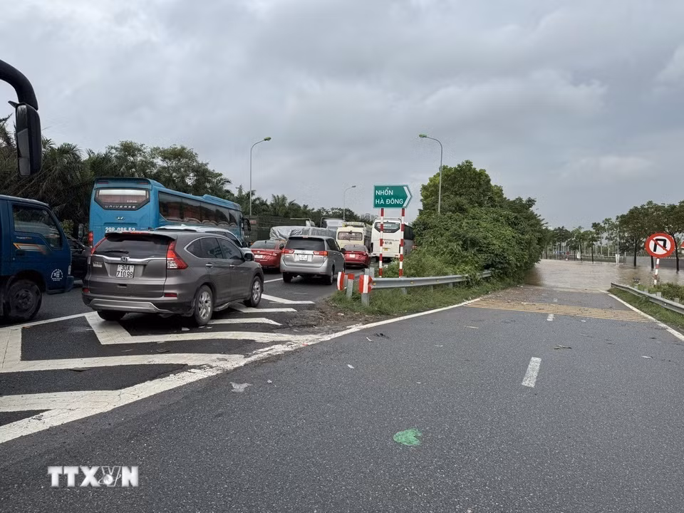 Nước ngập đường gom khiến các phương tiện không thể lưu thông. (Ảnh: Quốc Lũy/TTXVN)