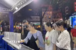 khách tham quan, trải nghiệm tại không gian "Sách mở tri thức - Công nghệ dẫn tương lai.” (Ảnh: Tuyết Mai/TTXVN)