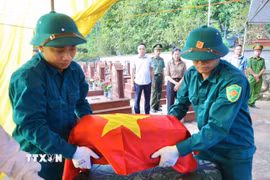 Lực lượng chức năng thực hiện nhiệm vụ tại Nghĩa trang Liệt sỹ La Giang, xã Quang Sơn. (Ảnh: Thu Hằng/TTXVN)