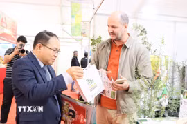 Tham tán Thương mại Việt Nam tại Algeria Hoàng Đức Nhuận trao đổi với doanh nghiệp Algeria. (Ảnh: Mạnh Hùng/TTXVN)