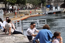 Người dân tránh nóng bên bờ sông Seine tại Paris, Pháp. (Ảnh: THX/TTXVN)