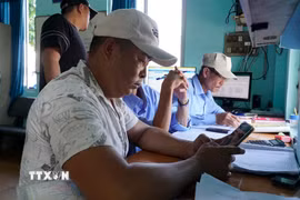 Ngư dân thực hiện khai báo điện tử trước khi vươn khơi. (Ảnh: Đình Quân/TTXVN)