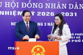 Thủ tướng Phạm Minh Chính và Phu nhân bỏ phiếu bầu tại Khu vực bỏ phiếu số 21, phường Tây Hồ, thành phố Hà Nội. (Ảnh: Dương Giang/TTXVN)