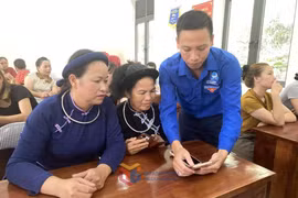 Đoàn viên thanh niên xã Điền Xá hướng dẫn cho người dân các tiện ích số. (Ảnh: Cổng Thông tin điện tử tỉnh Quảng Ninh)