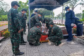 Lực lượng chuyên môn tiến hành đưa hài cốt liệt sỹ ra khỏi mộ để lấy mẫu giám định. (Ảnh minh họa. Thanh Liêm/TTXVN)