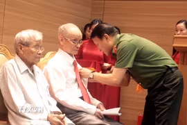 Đại tướng Lương Tam Quang, Ủy viên Bộ Chính trị, Bộ trưởng Bộ Công an trao tặng Huy hiệu 80 năm tuổi Đảng cho các đảng viên. (Ảnh: Đinh Văn Nhiều/TTXVN)