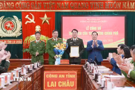Chủ tịch Ủy ban Nhân dân tỉnh Lai Châu, Hà Quang Trung tặng hoa và trao thư khen của Thủ tướng Chính phủ cho Ban Giám đốc Công an tỉnh Lai Châu. (Ảnh: Quý Trung/TTXVN)