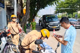 Cán bộ Đội Cảnh sát giao thông đường bộ số 1 (Công an Hà Nội) lập biên bản xử lý trường hợp vi phạm quy định về dừng, đỗ xe tại khu vực phố cổ Hà Nội. (Ảnh: Trung Nguyên/TTXVN)