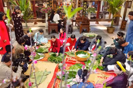 Giữa lòng phố cổ, cùng gói bánh chưng đón Tết như cách của người Hà Nội xưa. (Ảnh: Thanh Tùng/TTXVN)