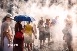 Người dân làm mát dưới hệ thống phun sương ở Budapest, Hungary. (Ảnh: THX/TTXVN phát)