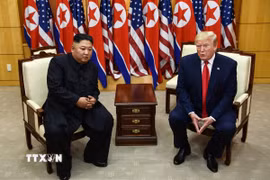Tổng thống Mỹ Donald Trump (phải) và nhà lãnh đạo Triều Tiên Kim Jong-un trong cuộc gặp ở làng đình chiến Panmunjom tại Khu phi quân sự (DMZ) chiều 30/6/2019. (Ảnh: AFP/TTXVN)