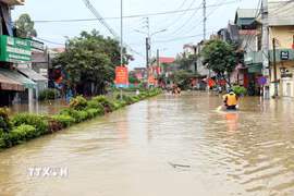 Người dân xã Thất Khê, tỉnh Lạng Sơn di chuyển bằng bè trên Quốc lộ 4A. (Ảnh: Văn Đạt/TTXVN)