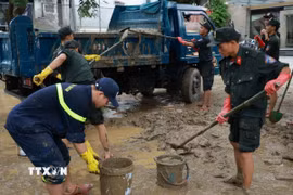 Đoàn công tác Công an tỉnh Quảng Trị có mặt tại thành phố Huế và khẩn trương tiến hành dọn vệ sinh môi trường, đẩy bùn đất tại các cơ quan, đơn vị. (Ảnh: TTXVN phát)