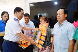 Đại diện Bộ Tư lệnh Vùng Cảnh sát biển 4 tặng cờ Tổ quốc, ảnh Bác Hồ và áo phao cho ngư dân xã Hòa Điền, tỉnh An Giang.