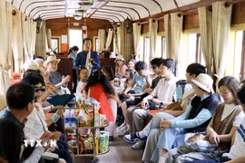 Biểu diễn âm nhạc phục vụ du khách trên chuyến tàu từ Ga Đà Lạt đến Ga Trại Mát (Lâm Đồng). (Ảnh: Nguyễn Huy Thành/TTXVN)