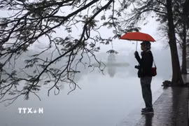 Sương mù từ sáng sớm ở khu vực Hồ Hoàn Kiếm. (Ảnh: Mai Hiền/TTXVN phát)