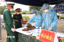 Lực lượng chức năng lấy mẫu hài cốt liệt sỹ chưa xác định được thông tin tại Nghĩa trang Liệt sỹ Tiểu Cần theo đúng quy trình kỹ thuật, phục vụ giám định ADN. (Ảnh: Thanh Hòa/TTXVN)