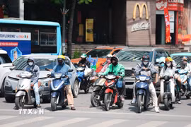 Khẩu trang, áo chống nắng là những thứ không thể thiếu cảu người dân ở Hà Nội khi tham gia giao thông trong những ngày nắng nóng. (Ảnh: Lê Đông/TTXVN)