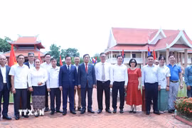 Đại sứ Nguyễn Minh Tâm cùng đoàn đại biểu chụp ảnh kỷ niệm tại Khu lưu niệm Chủ tịch Hồ Chí Minh ở bản Xiengvang, huyện Nongbok, tỉnh Khammouane. (Ảnh: Xuân Tú/TTXVN)