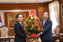 Thứ trưởng Bộ Ngoại giao Lào tặng hoa chúc mừng 95 năm ngày thành lập Đảng Cộng sản Việt Nam và Tết cổ truyền Ất tỵ 2025. (Ảnh: Xuân Tú/TTXVN)