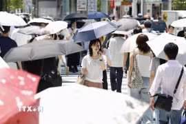 Người dân di chuyển dưới trời nắng gắt tại Ginza, Nhật Bản. (Ảnh: Kyodo/TTXVN)