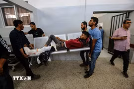 Chuyển người Palestine bị thương sau cuộc tấn công của Israel nhằm vào một trung tâm phân phối hàng viện trợ ở Dải Gaza. (Ảnh: THX/TTXVN)