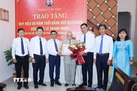 Thường trực Ban Bí thư Trần Cẩm Tú trao Huy hiệu 80 năm tuổi Đảng cho đảng viên lão thành Lê Thanh Minh, phường Hội An, thành phố Đà Nẵng. (Ảnh: Phương Hoa/TTXVN)