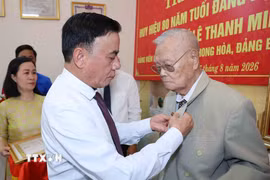 Thường trực Ban Bí thư Trần Cẩm Tú gắn Huy hiệu 80 năm tuổi Đảng cho đảng viên lão thành Lê Thanh Minh, phường Hội An, thành phố Đà Nẵng. (Ảnh: Phương Hoa/TTXVN)