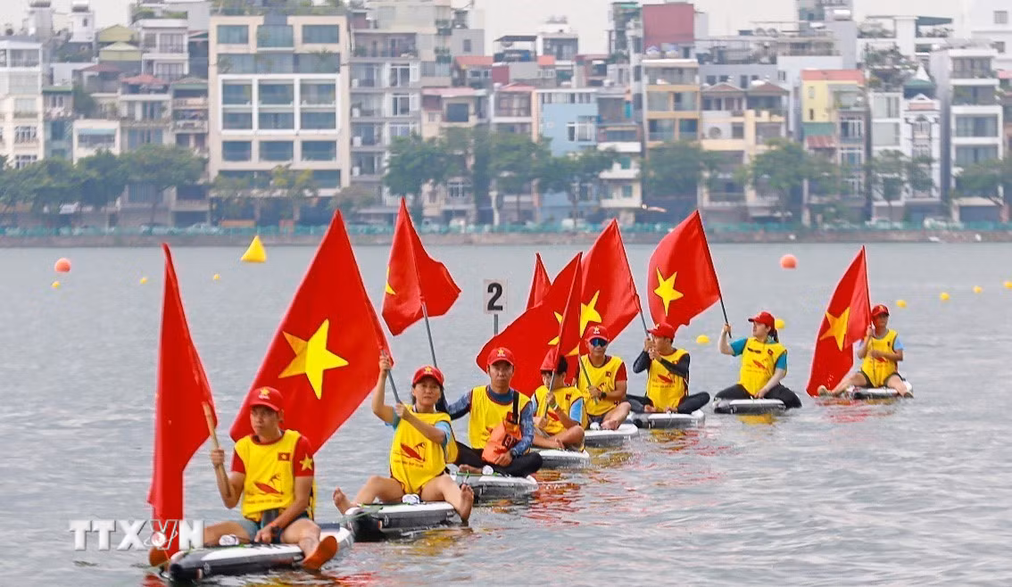 Các đội thuyền diễu hành trên mặt nước Hồ Tây, tạo nên khung cảnh sôi động trong ngày hội thể thao. (Ảnh: Khánh Hòa/TTXVN)