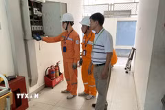 Công nhân (EVNHANOI) hướng dẫn khách hàng sử dụng điện an toàn, tiết kiệm. (Ảnh: Quốc Lũy/ TTXVN)