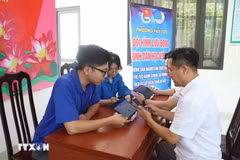 Lực lượng đoàn thanh niên cơ sở tích cực hỗ trợ người dân thực hiện "Bình dân học vụ số". (Ảnh: Nguyễn Cúc/TTXVN)